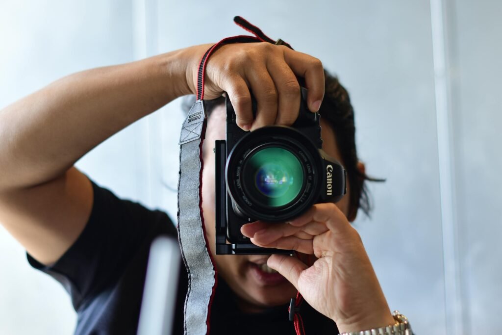 Close-up shot of a photographer with a DSLR camera capturing a photo indoors.